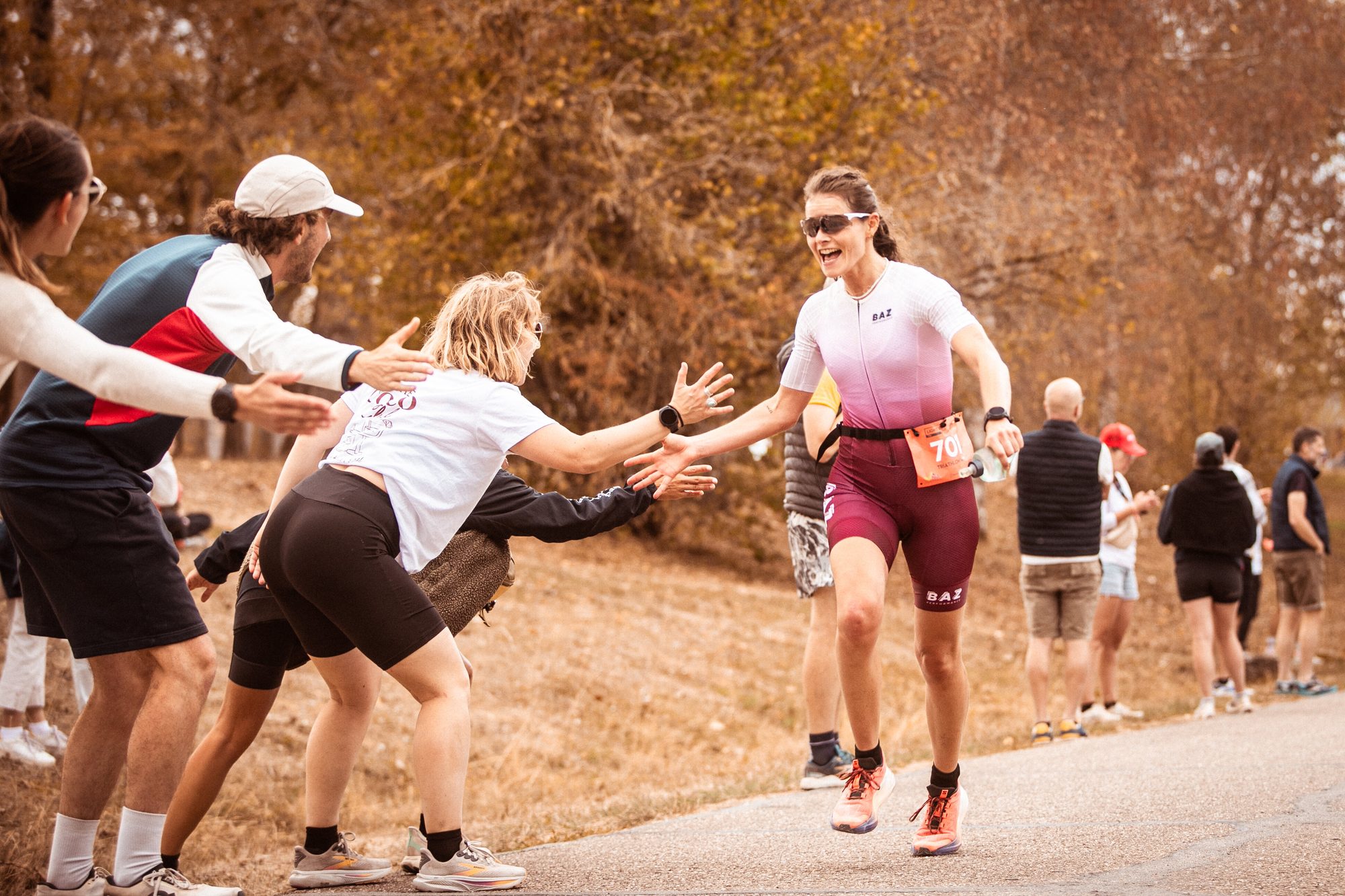 Triathlète en course à pied qui tape dans les mains du public à Madine